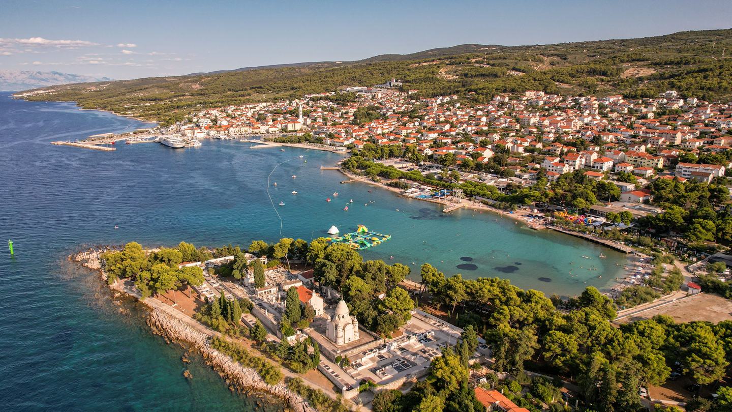 Novalja na otoku Pagu iz zraka, uvala i gradska plaža u punoj sezoni