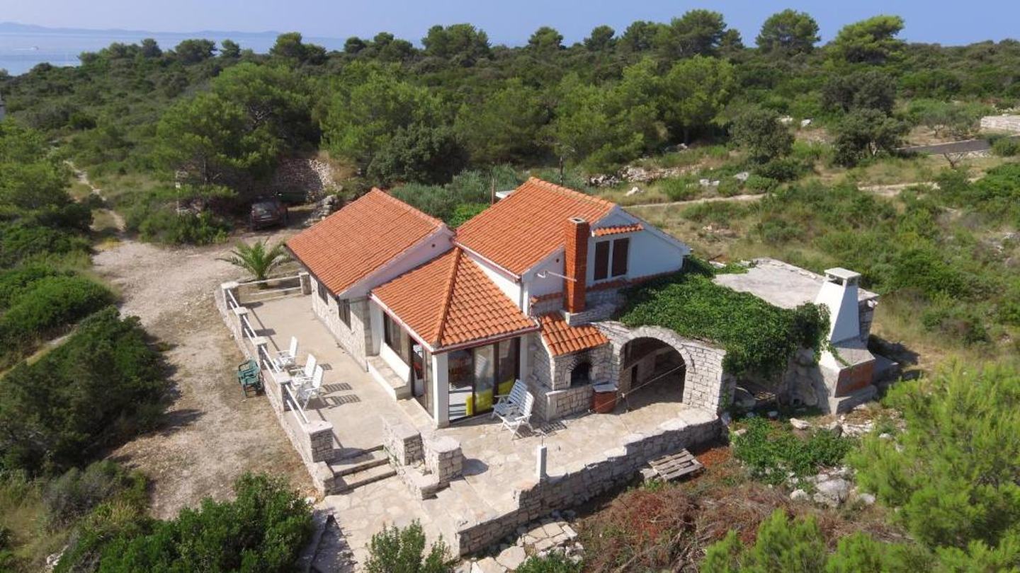 Kamena kuća za odmor na Šolti s terasom i vanjskim kaminom, okružena borovima